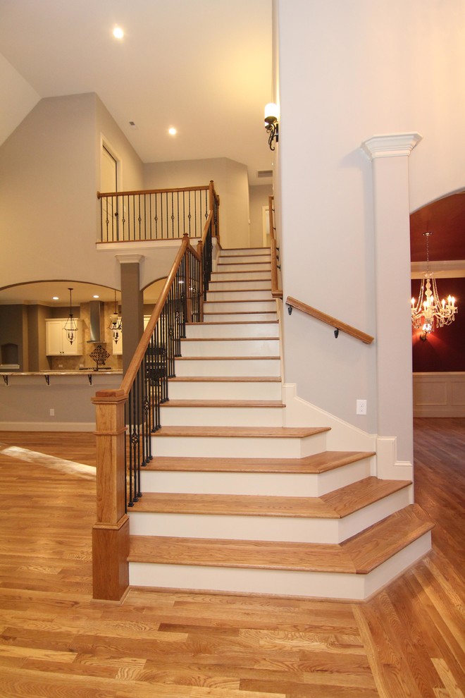 Example of a large classic wooden straight staircase design in Raleigh with painted risers
