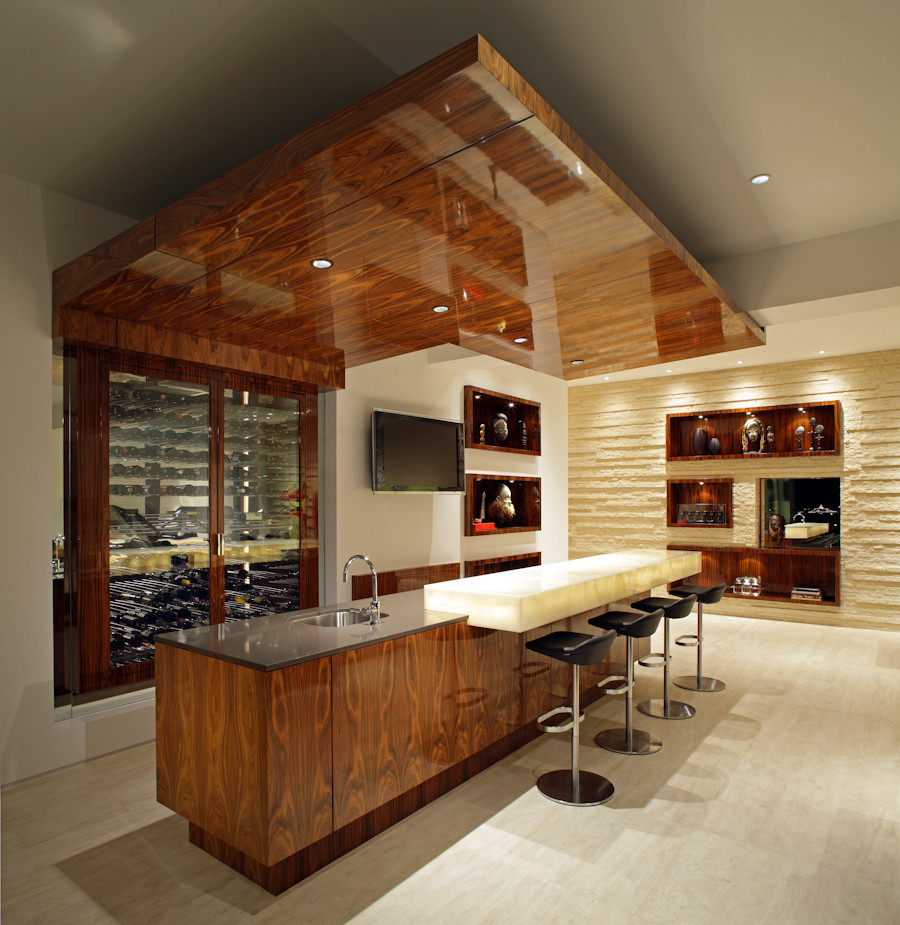 Photo of a mid-sized contemporary galley seated home bar in Orange County with an undermount sink, solid surface benchtops, light hardwood floors and beige floor.