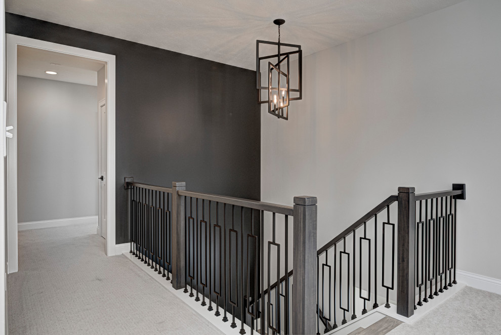 This is an example of a mid-sized country wood u-shaped staircase in Indianapolis with wood railing.