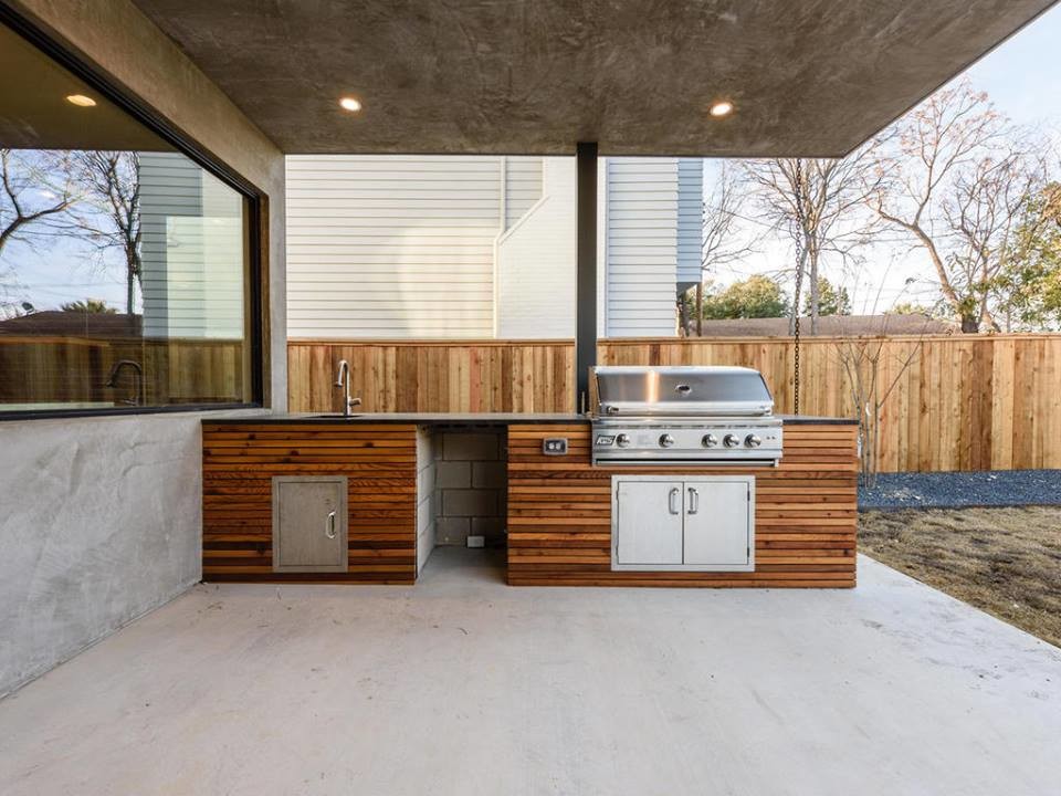 Large contemporary backyard patio in Austin with an outdoor kitchen, concrete slab and a roof extension.