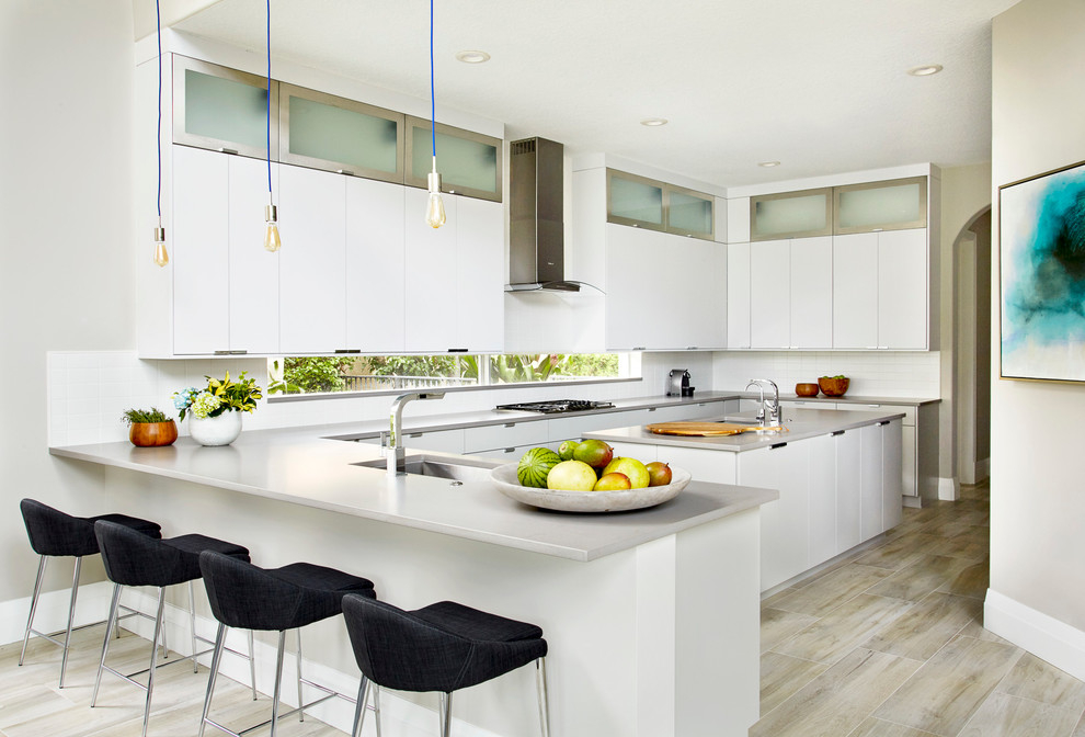 Large trendy u-shaped light wood floor and beige floor eat-in kitchen photo in Miami with an undermount sink, flat-panel cabinets, white cabinets, white backsplash, stainless steel appliances, a peninsula, quartz countertops and ceramic backsplash
