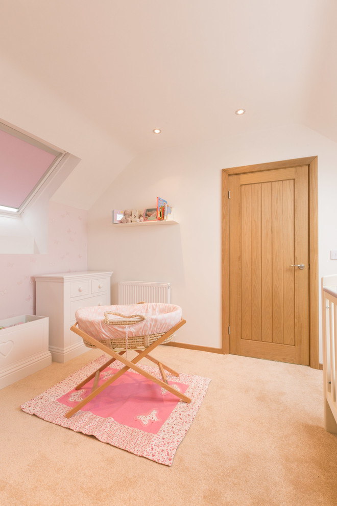 Design ideas for a mid-sized country nursery for girls in Other with pink walls.