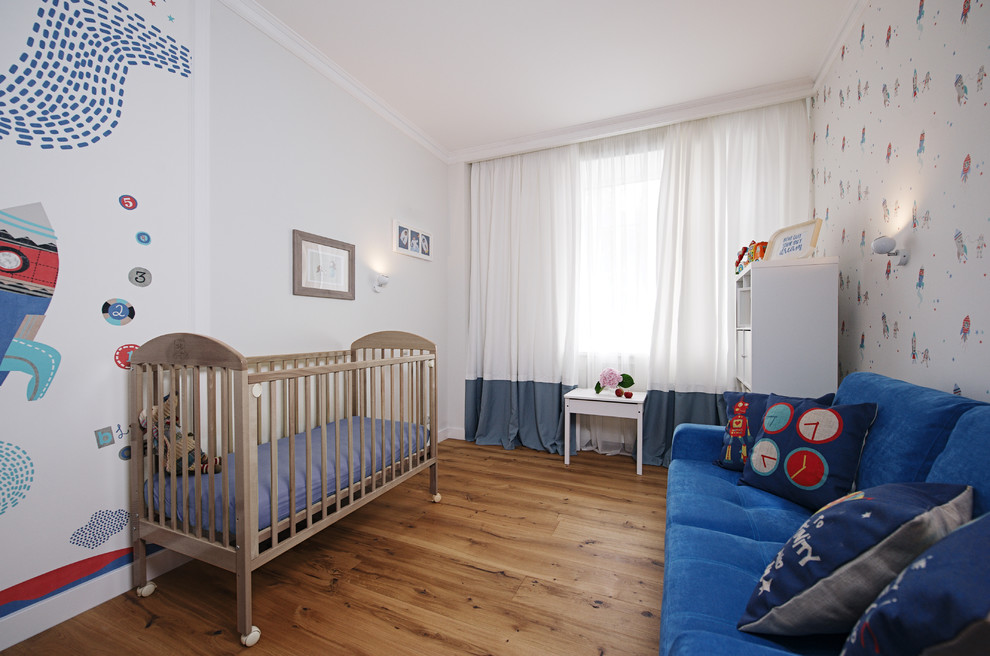 Design ideas for a contemporary nursery for boys in Moscow with multi-coloured walls and medium hardwood floors.