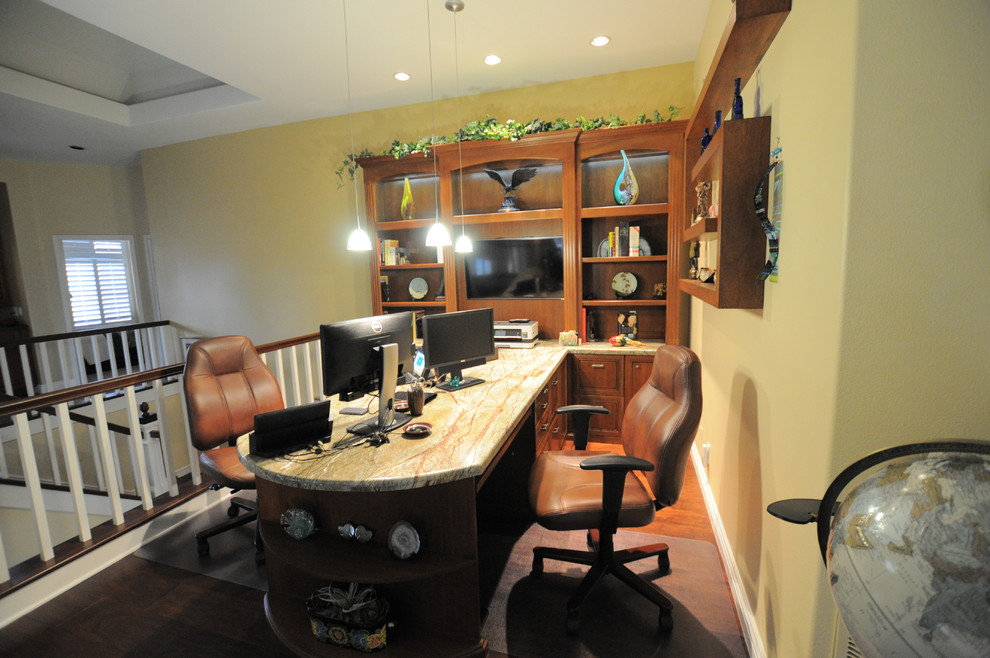 This is an example of a mid-sized traditional study room in Los Angeles with beige walls, dark hardwood floors, no fireplace and a built-in desk.