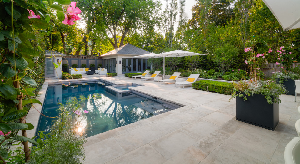 Example of a mid-sized minimalist backyard stone and rectangular pool design