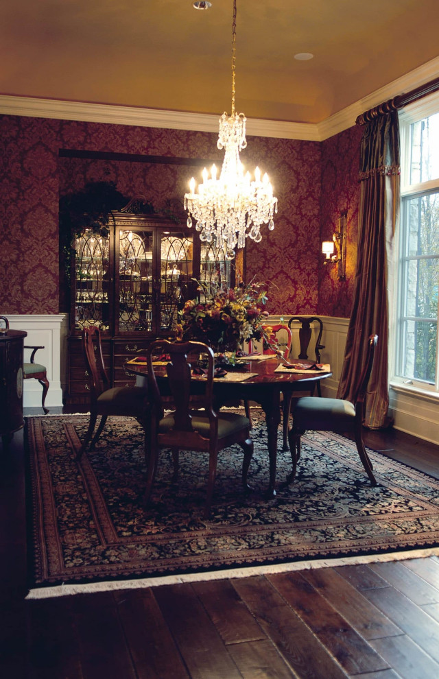 Réalisation d'une salle à manger tradition avec un mur rouge, parquet foncé, un sol marron et du papier peint.