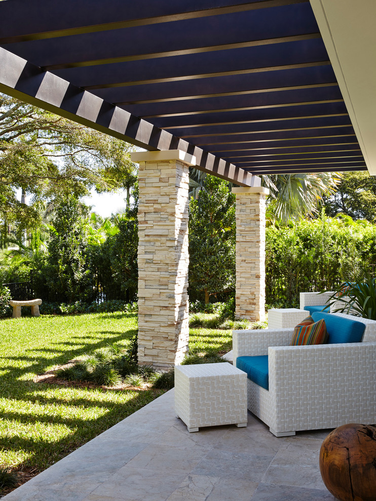 Photo of an expansive contemporary backyard patio in Miami with tile and a pergola.