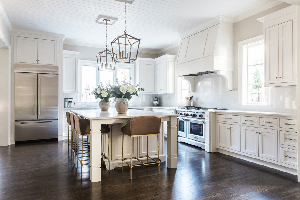 Inspiration for a traditional l-shaped kitchen in Charlotte with shaker cabinets, white cabinets, yellow splashback, stone slab splashback, stainless steel appliances, dark hardwood floors, with island, brown floor and white benchtop.