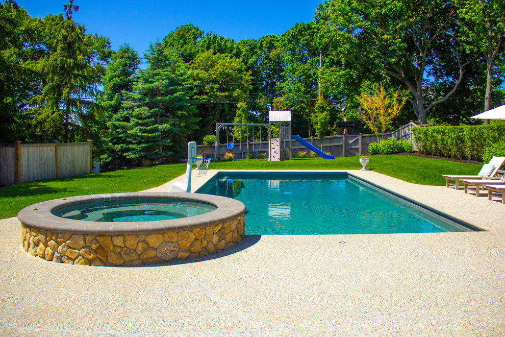This is an example of a large contemporary backyard rectangular natural pool in Boston with a hot tub and decking.