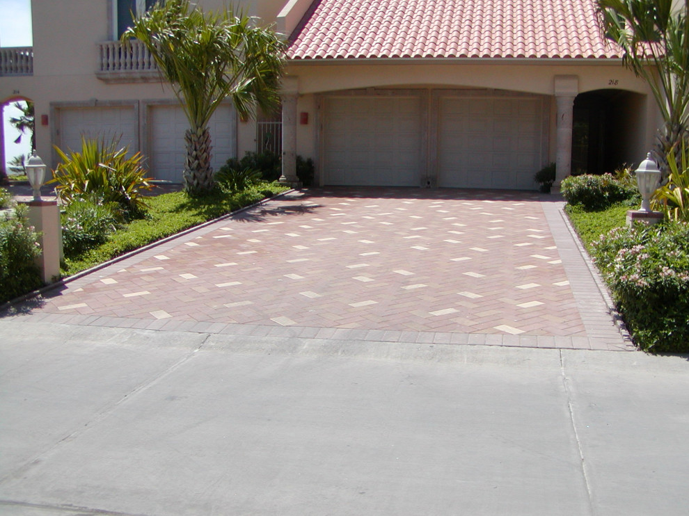 Large contemporary front yard driveway in Austin with brick pavers.