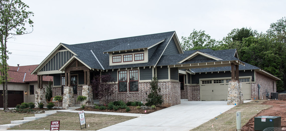 Photo of a large arts and crafts one-storey grey house exterior in Oklahoma City with mixed siding, a gable roof and a shingle roof.