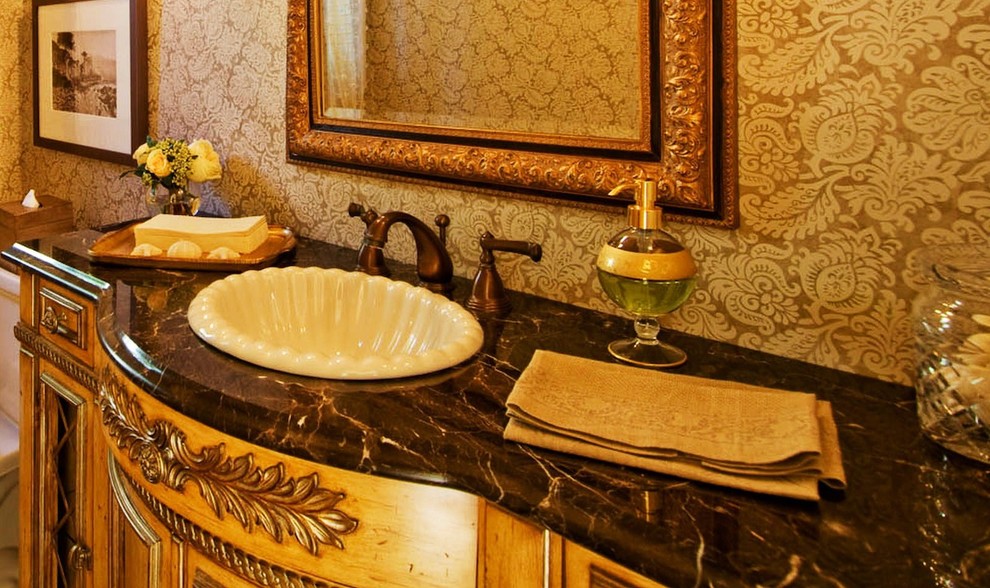 Inspiration for a small traditional powder room in Seattle with beaded inset cabinets, medium wood cabinets, a two-piece toilet, yellow walls, a drop-in sink and marble benchtops.