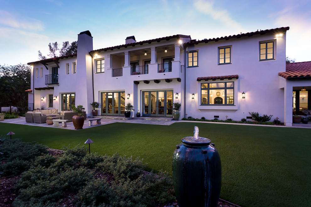 Photo of a mediterranean two-storey stucco white house exterior in Los Angeles with a tile roof.