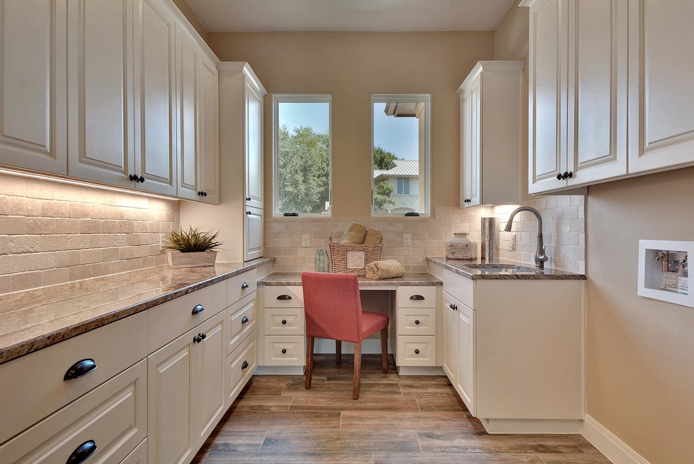 Example of a large transitional u-shaped porcelain tile utility room design in Austin with an undermount sink, raised-panel cabinets, white cabinets, beige walls, granite countertops and a side-by-side washer/dryer