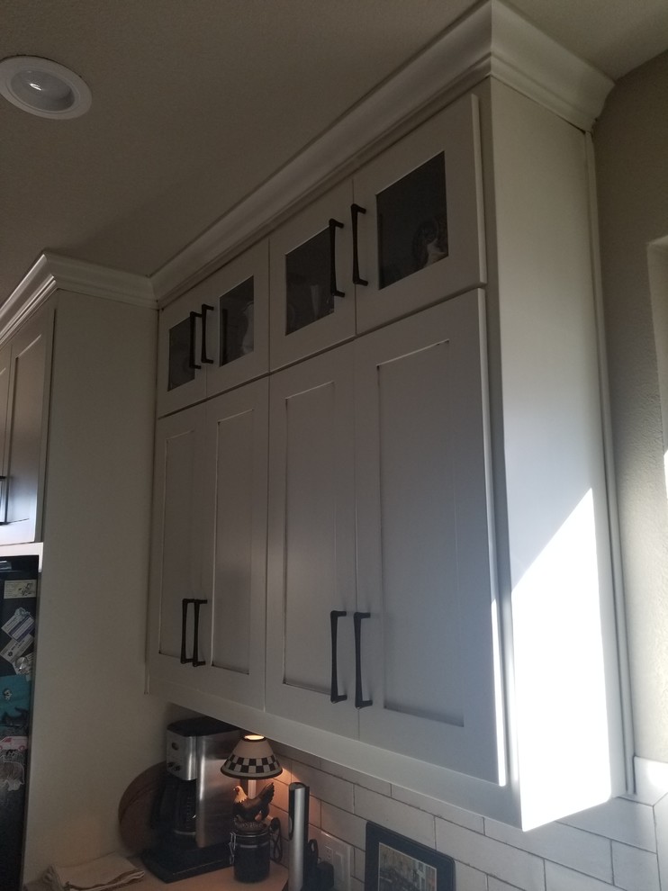 Transitional kitchen photo in Dallas with shaker cabinets, white backsplash, stainless steel appliances and white countertops