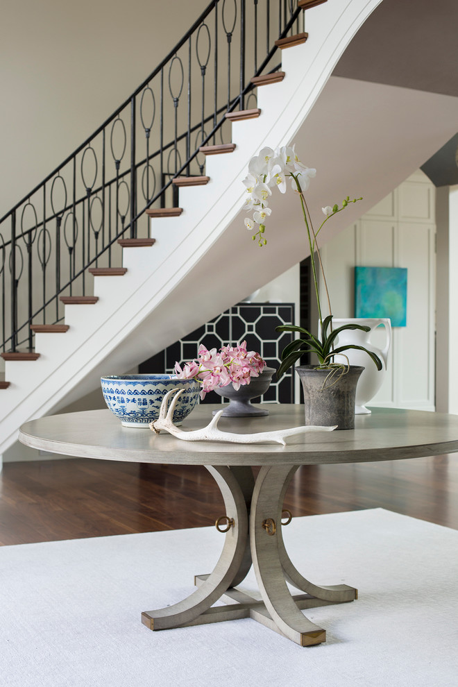 Huge transitional medium tone wood floor foyer photo with gray walls and a dark wood front door