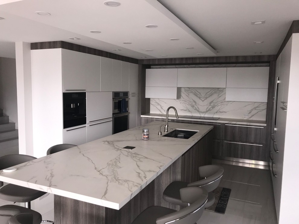Photo of a large contemporary u-shaped separate kitchen in Other with an undermount sink, flat-panel cabinets, white cabinets, multi-coloured splashback, porcelain splashback, panelled appliances, porcelain floors, with island, multi-coloured floor and multi-coloured benchtop.