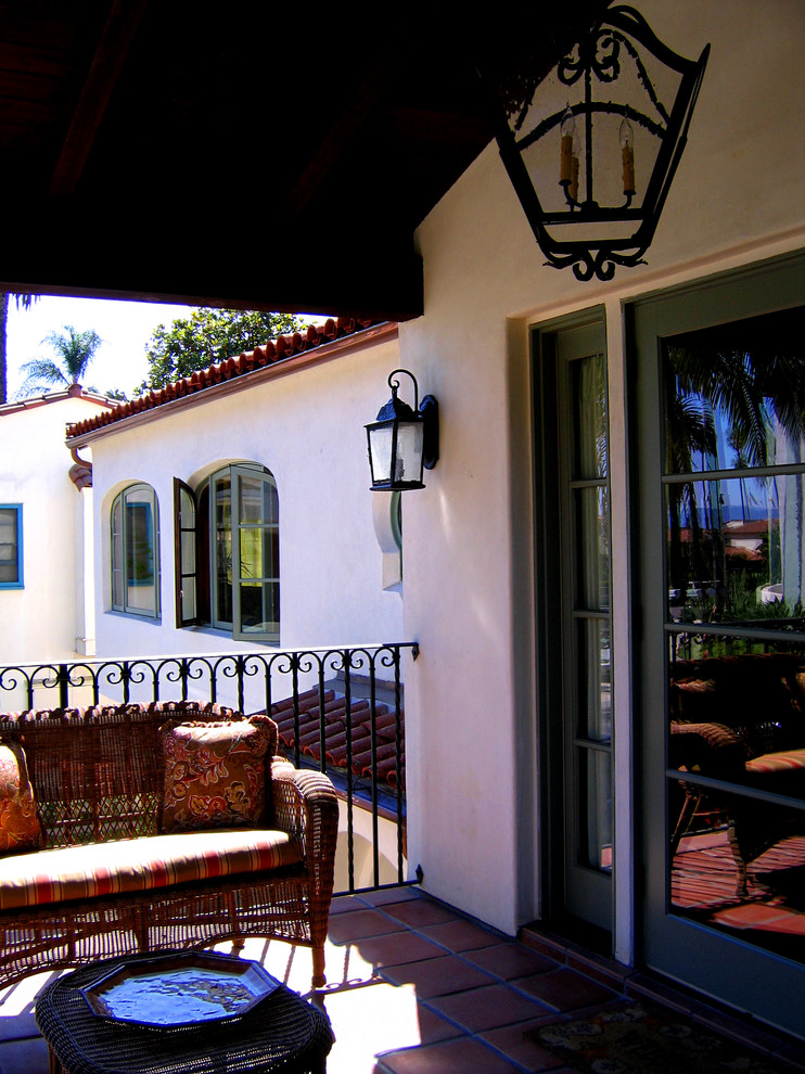 Photo of a mid-sized mediterranean two-storey stucco white house exterior in Santa Barbara with a hip roof and a tile roof.
