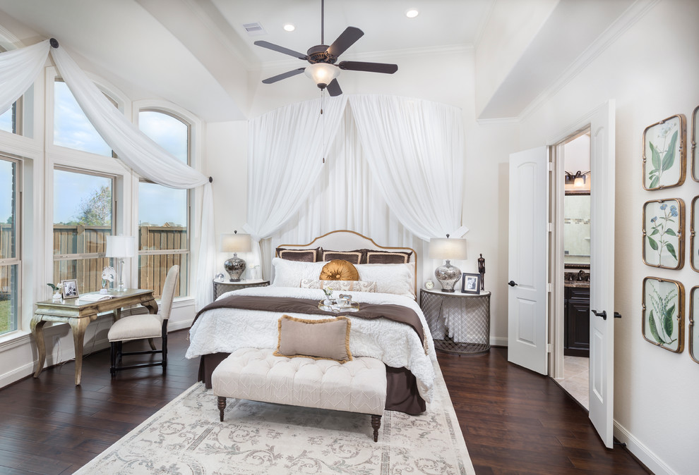 Traditional bedroom in Houston with white walls, dark hardwood floors, no fireplace and brown floor.