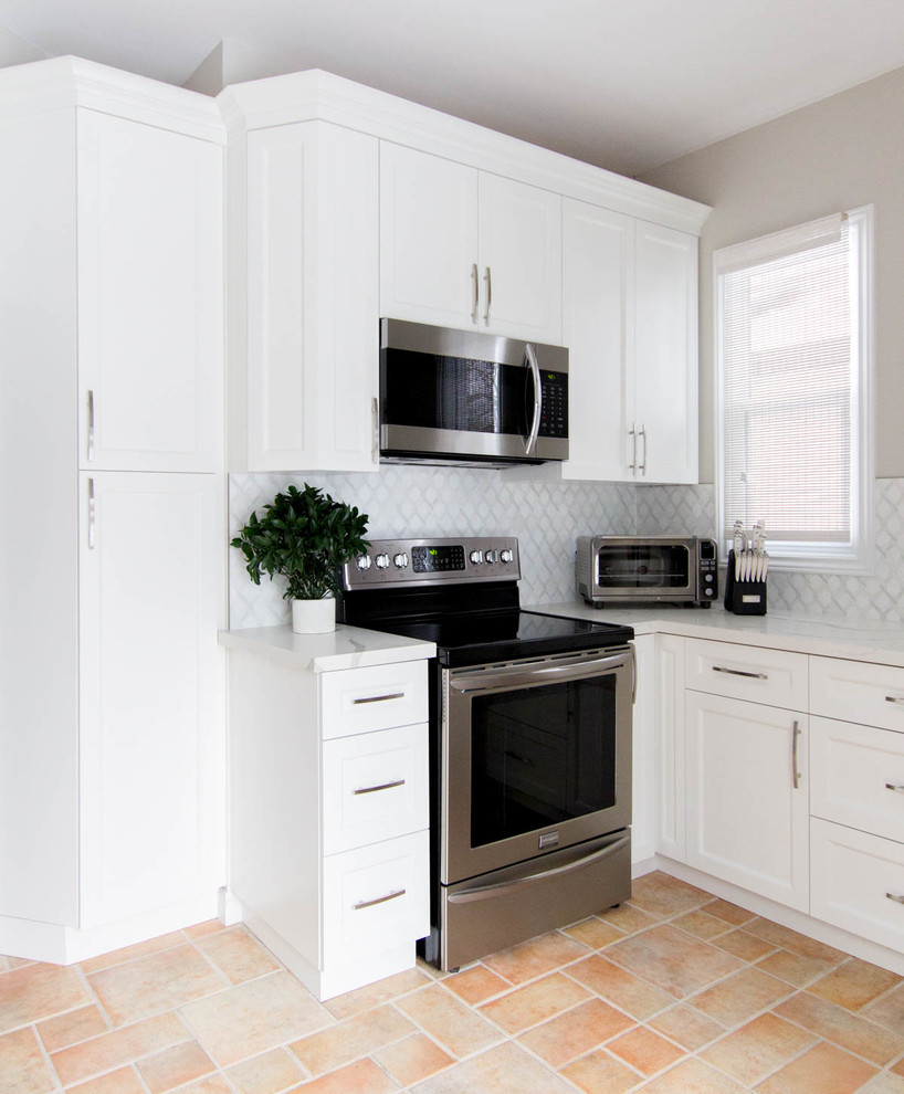 Inspiration for a small transitional u-shaped separate kitchen in Toronto with an undermount sink, shaker cabinets, white cabinets, quartzite benchtops, white splashback, mosaic tile splashback, stainless steel appliances, terra-cotta floors, no island, orange floor and white benchtop.