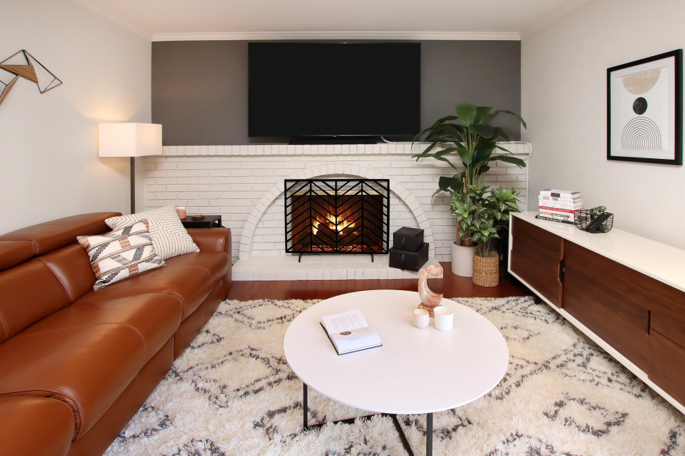 Family room - mid-sized 1960s enclosed dark wood floor and red floor family room idea in San Francisco with beige walls and a tv stand