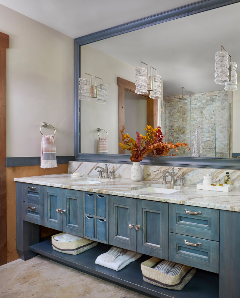 Inspiration for a large country master bathroom in Denver with blue cabinets, beige tile, stone tile, beige walls, limestone floors, an undermount sink, marble benchtops, beige floor, a hinged shower door, multi-coloured benchtops, a double vanity, a built-in vanity, decorative wall panelling, a freestanding tub, a curbless shower and recessed-panel cabinets.