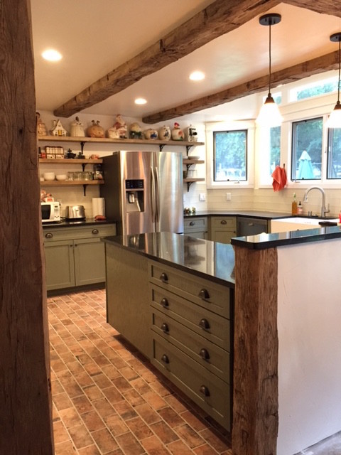 Inspiration for a mid-sized country l-shaped eat-in kitchen in San Luis Obispo with a farmhouse sink, raised-panel cabinets, green cabinets, quartz benchtops, white splashback, glass tile splashback, stainless steel appliances, porcelain floors, a peninsula and red floor.