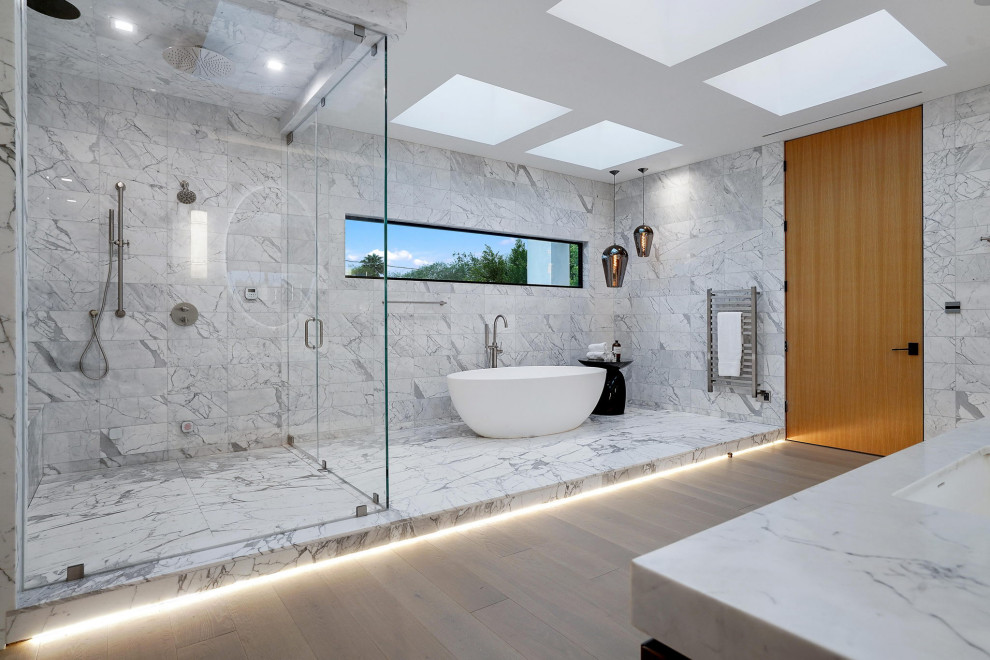 Cette image montre une très grande salle de bain principale minimaliste en bois brun avec un placard à porte plane, une baignoire indépendante, une douche à l'italienne, un carrelage blanc, des carreaux de porcelaine, un mur blanc, un lavabo encastré, un plan de toilette en surface solide, une cabine de douche à porte battante, un plan de toilette blanc, meuble double vasque, un plafond à caissons, un sol en carrelage de porcelaine et un sol blanc.