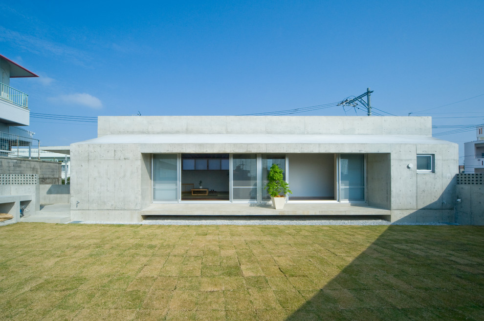 This is an example of a modern concrete grey exterior in Other with a flat roof.