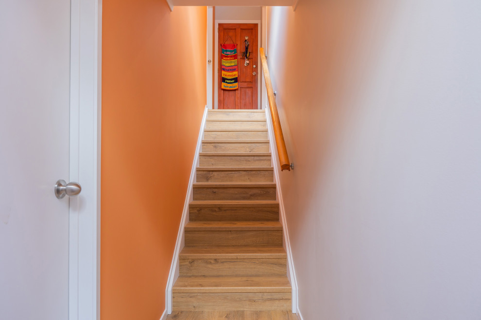 Imagen de escalera recta pequeña con escalones de madera, contrahuellas de madera y barandilla de madera