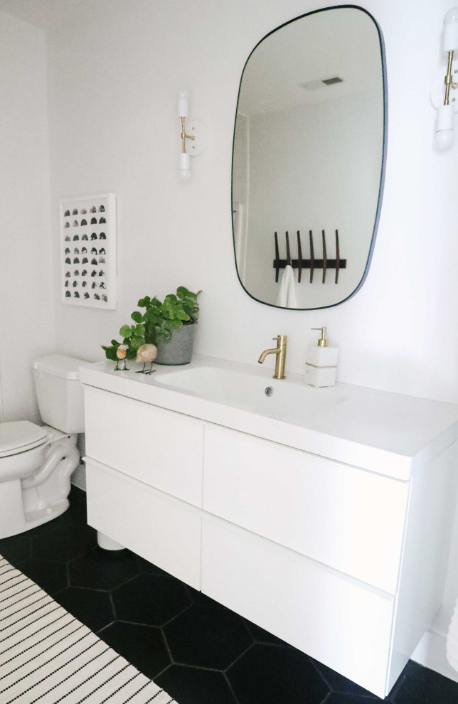 Design ideas for a mid-sized scandinavian kids bathroom in Other with flat-panel cabinets, white cabinets, a one-piece toilet, white walls, porcelain floors, an integrated sink, black floor, a sliding shower screen, white benchtops, a single vanity and a floating vanity.