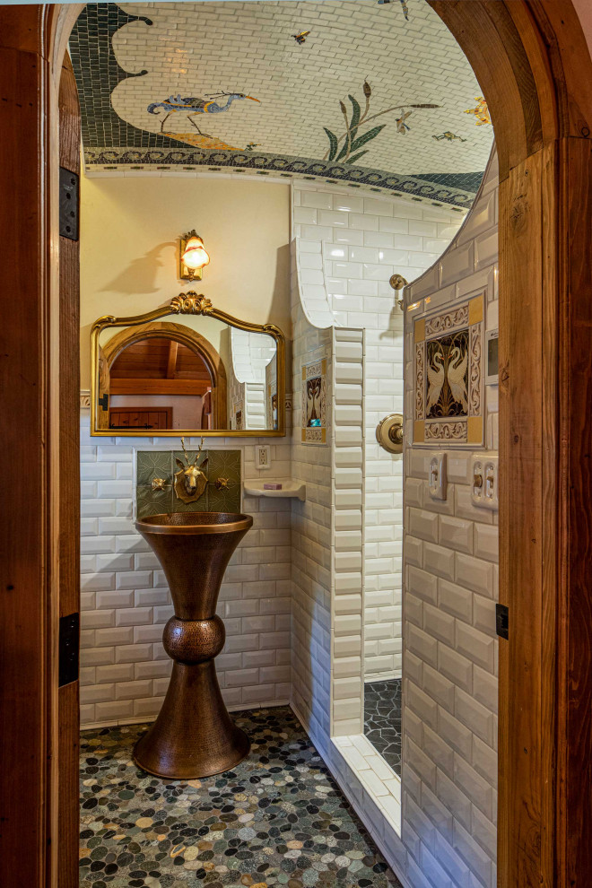 Eklektisk inredning av ett en-suite badrum, med en dusch i en alkov, vit kakel, keramikplattor, vita väggar, klinkergolv i småsten, ett piedestal handfat och med dusch som är öppen