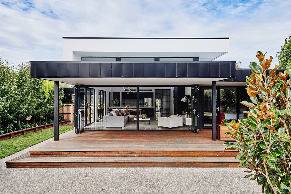 This is an example of a mid-sized modern one-storey white house exterior in Geelong with metal siding, a flat roof and a metal roof.