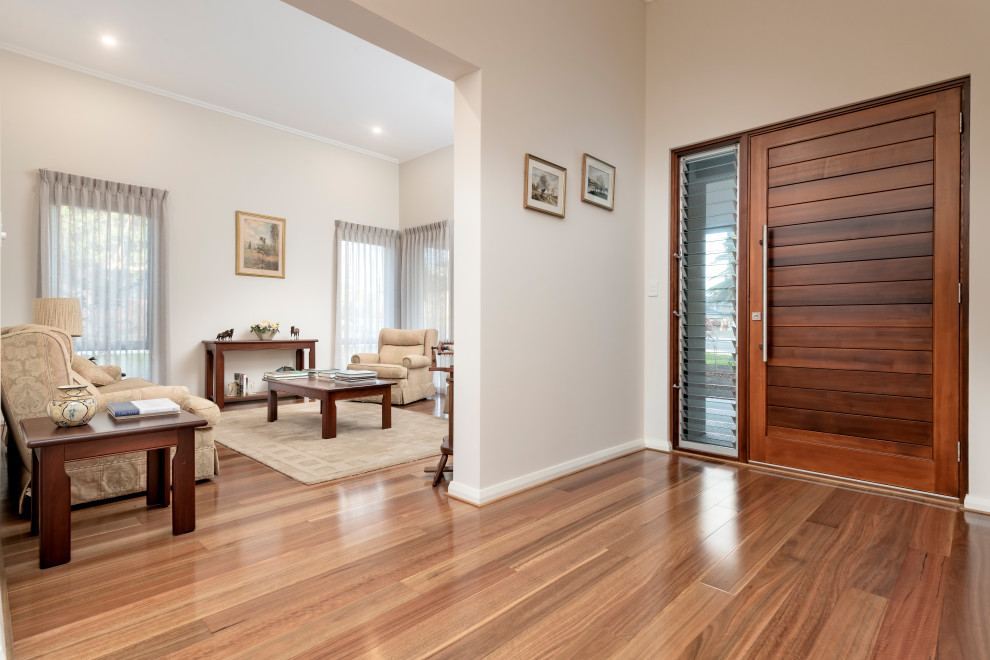 This is an example of an expansive contemporary front door in Perth with light hardwood flooring and a single front door.