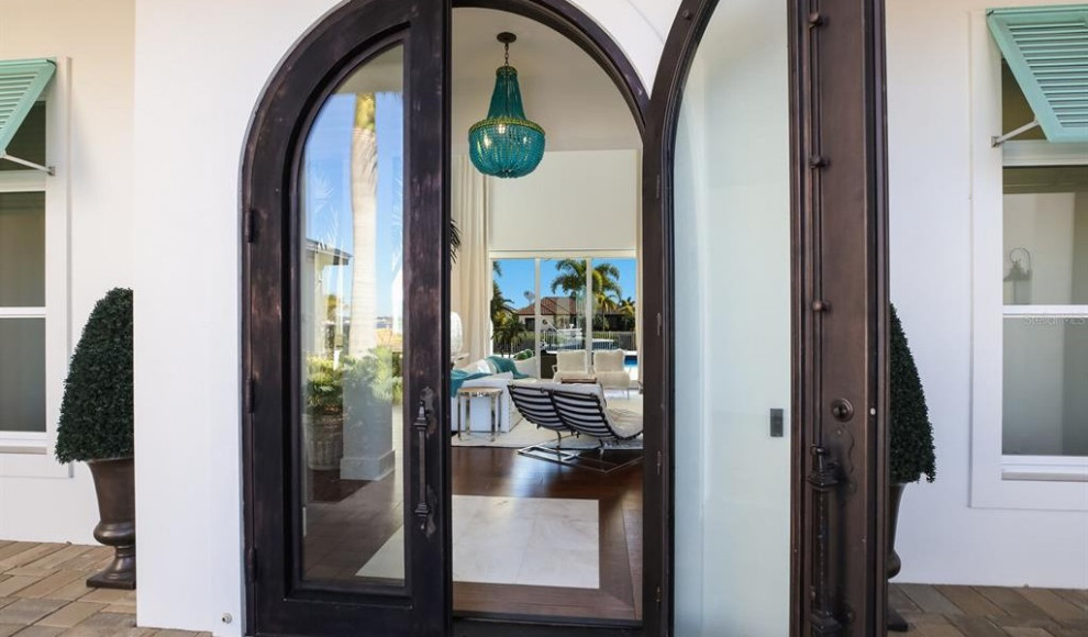Photo of an expansive contemporary front door in Tampa with white walls, terrazzo floors, a double front door, a dark wood front door, white floor and vaulted.