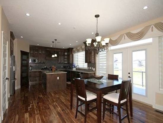 Inspiration for an u-shaped eat-in kitchen in Calgary with flat-panel cabinets, dark wood cabinets and with island.