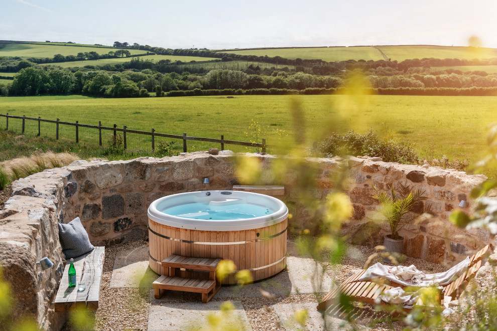 Esempio di una piscina fuori terra country rotonda di medie dimensioni e dietro casa con una vasca idromassaggio e ghiaia
