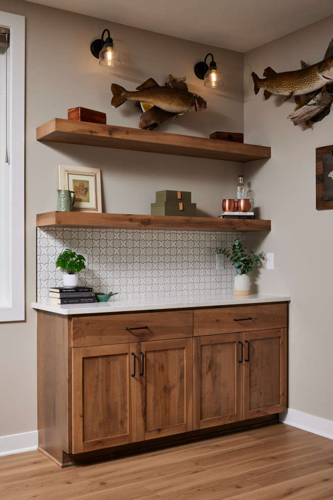 Inspiration for a small transitional single-wall vinyl floor and brown floor dry bar remodel in Minneapolis with no sink, shaker cabinets, medium tone wood cabinets, quartz countertops, white backsplash, mosaic tile backsplash and white countertops