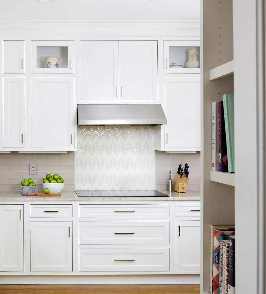 Inspiration for a mid-sized transitional l-shaped eat-in kitchen in DC Metro with white cabinets, beige splashback, subway tile splashback, stainless steel appliances and medium hardwood floors.
