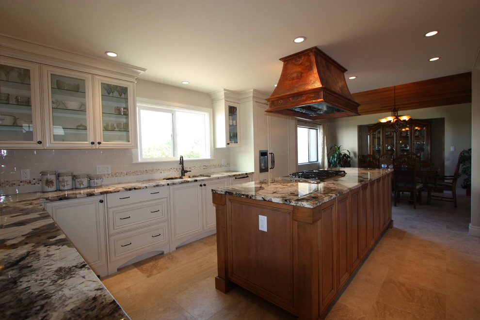 Kitchen pantry - mid-sized rustic l-shaped porcelain tile and beige floor kitchen pantry idea in Vancouver with an undermount sink, raised-panel cabinets, white cabinets, granite countertops, beige backsplash, ceramic backsplash, stainless steel appliances and an island