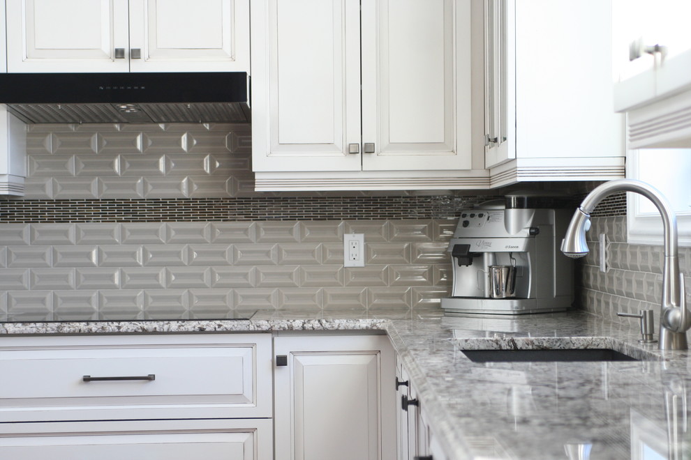 Open concept kitchen - huge transitional l-shaped medium tone wood floor and brown floor open concept kitchen idea in Montreal with an undermount sink, glass-front cabinets, white cabinets, granite countertops, gray backsplash, ceramic backsplash, stainless steel appliances, an island and multicolored countertops