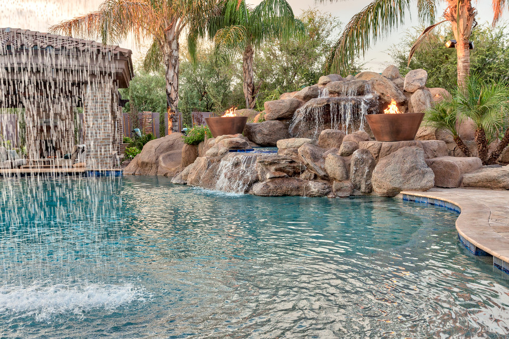 Inspiration for a large mediterranean backyard natural pool in Phoenix with natural stone pavers.