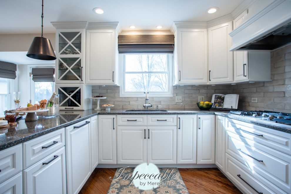 Inspiration for a large transitional u-shaped medium tone wood floor and brown floor eat-in kitchen remodel in Chicago with an undermount sink, raised-panel cabinets, white cabinets, quartz countertops, beige backsplash, subway tile backsplash, paneled appliances, a peninsula and multicolored countertops