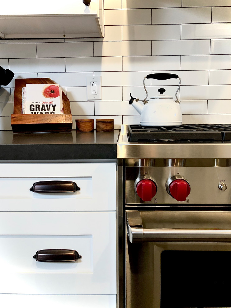 Country galley eat-in kitchen in Los Angeles with a farmhouse sink, shaker cabinets, white splashback, ceramic splashback, stainless steel appliances, porcelain floors, grey floor and grey benchtop.