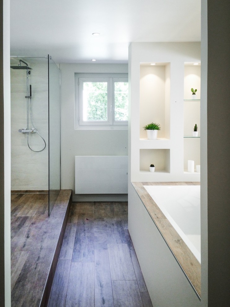 This is an example of a mid-sized beach style master bathroom in Dijon with open cabinets, an open shower, white walls, white cabinets, an alcove tub and white tile.