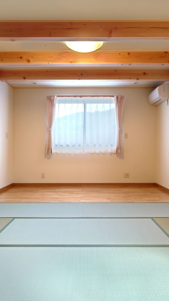 Foto di una grande camera matrimoniale etnica con pareti bianche, pavimento in tatami, travi a vista e carta da parati