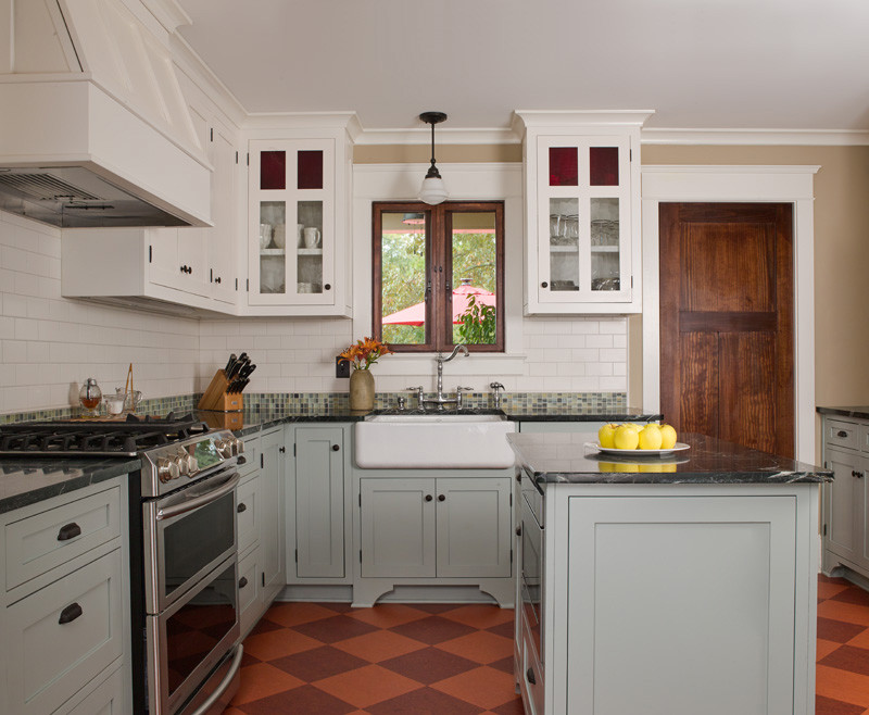 This is an example of a mid-sized arts and crafts u-shaped separate kitchen in Atlanta with a farmhouse sink, shaker cabinets, grey cabinets, soapstone benchtops, white splashback, subway tile splashback, stainless steel appliances, with island, multi-coloured floor, black benchtop and linoleum floors.