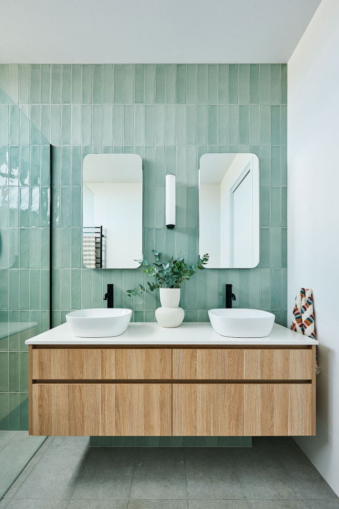 Inspiration for a large coastal ensuite bathroom in Geelong with flat-panel cabinets, light wood cabinets, a walk-in shower, green tiles, ceramic tiles, porcelain flooring, a pedestal sink, engineered stone worktops, grey floors, an open shower, white worktops and a freestanding vanity unit.