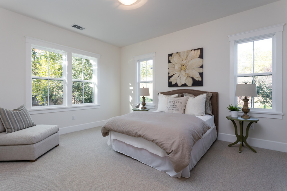 This is an example of a large country guest bedroom in San Francisco with white walls, carpet and beige floor.