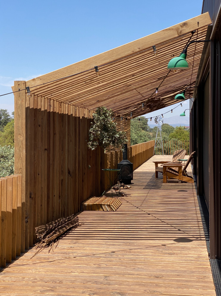 Mid-sized urban wood railing deck photo in Madrid with a pergola